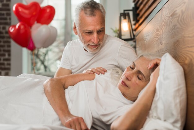 Senior hombre sorprendente esposa en la cama