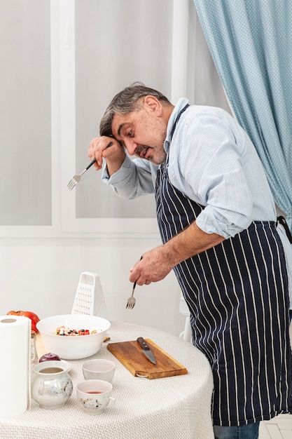 Senior hombre con tenedores para ensalada