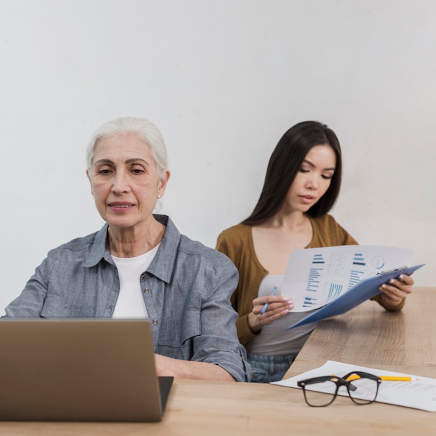 Foto gratuita senior y joven trabajando juntos