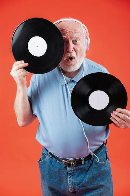 Foto gratuita senior juguetón con discos de música