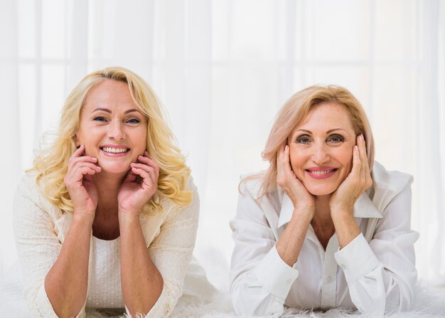 Senior mejores amigos sonriendo mientras mira a la cámara