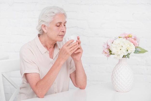 Foto gratuita senior mujer bebiendo una taza de café en casa