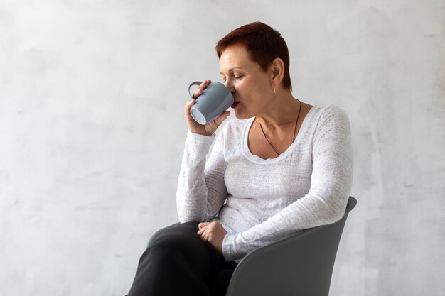 Senior mujer bebiendo de una taza