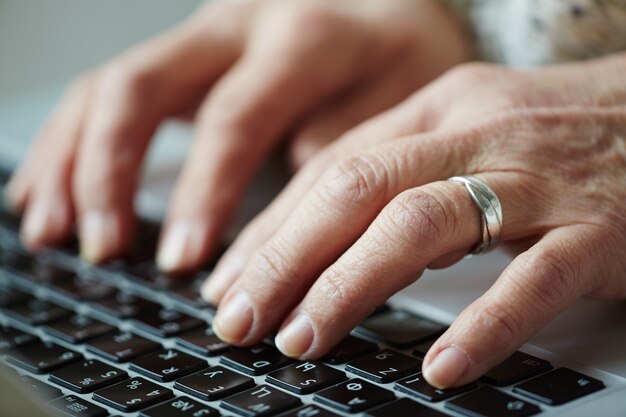 Senior mujer escribiendo en el teclado