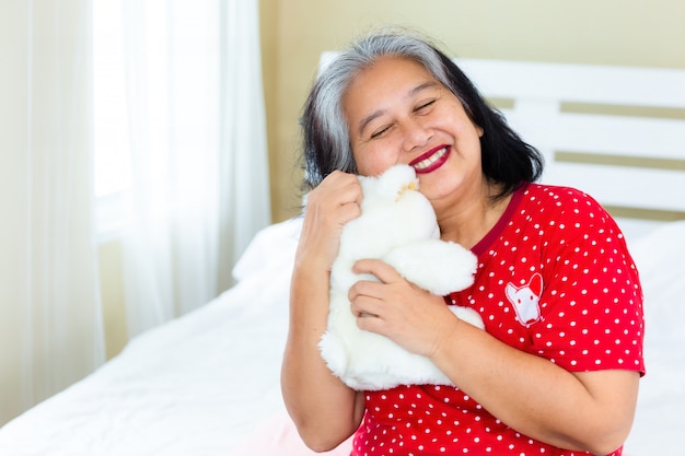 Senior mujer feliz con osito de peluche