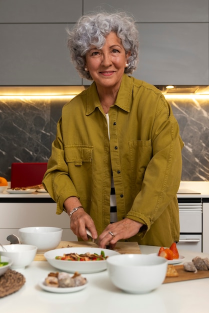 Foto gratuita senior mujer haciendo plato con higos en la cocina