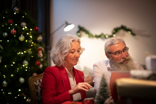 Foto gratuita senior mujer y hombre celebrando navidad