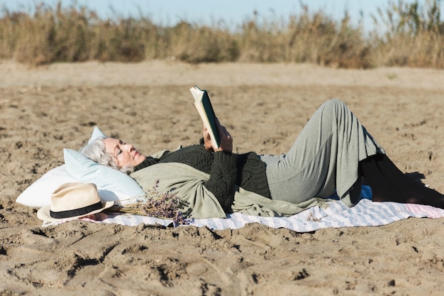 Senior mujer leyendo libro al aire libre