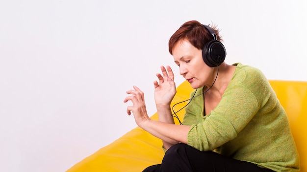 Senior mujer relajante escuchando música