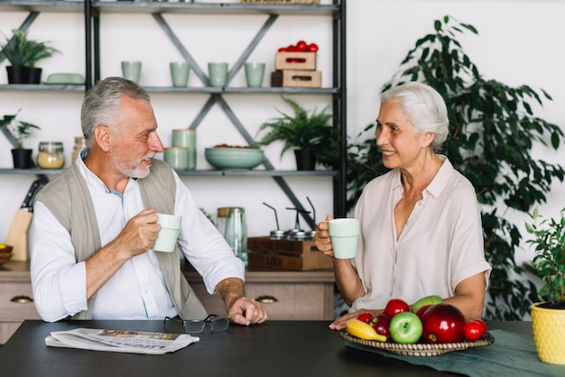 Foto gratuita senior pareja sentada en la cocina desayunando juntos