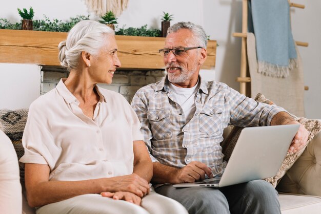 Senior pareja sentada en el sofá mirando el uno al otro