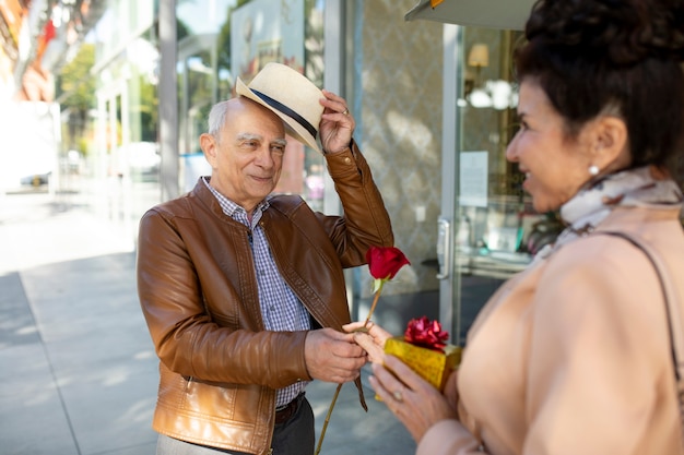 Senior pareja sorprendiéndose mutuamente con regalos