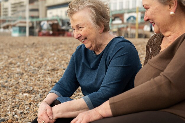 Senior sonriente mujer sentada en la playa