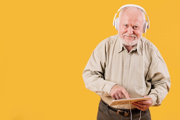 Foto gratuita senior tocando música en tableta