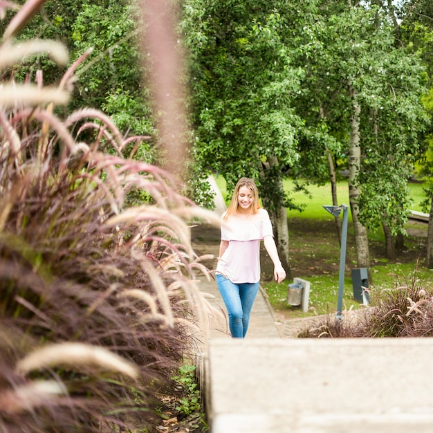 Señora alegre caminando en el parque de la ciudad