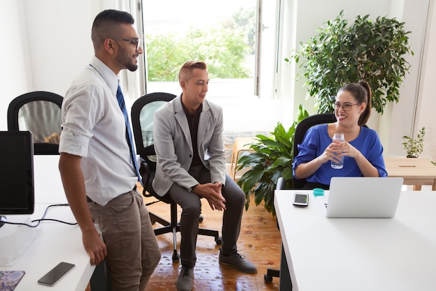 Señora alegre jefe hablando con los empleados