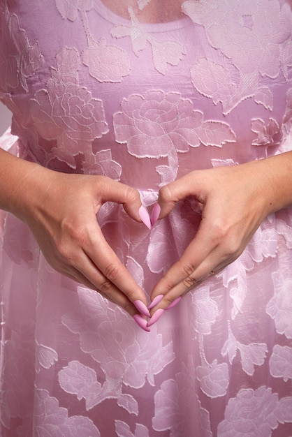 Señora anónima caucásica puso sus manos juntas en forma de corazón Concepto romántico atmósfera de luz de ensueño Símbolo de amor y atracción Vertical medio primer plano foto de alta calidad jpg