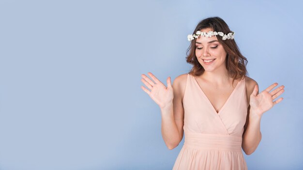 Señora apasionada feliz en vestido con flores blancas en la cabeza