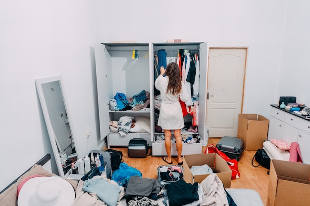 Señora de aspecto agradable dentro de la habitación moderna del apartamento prepararse para el viaje