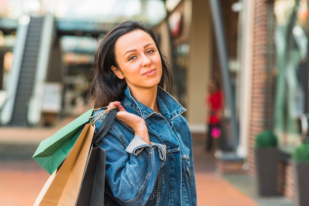 Foto gratuita señora atractiva con bolsas de compras en el centro comercial