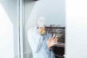 Foto gratuita señora bastante joven de pie en casa mirando la ventana