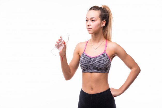 Señora bebiendo agua de una botella transparente sobre un blanco