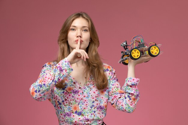 Señora bonita vista frontal muestra gesto de silencio con su coche de juguete