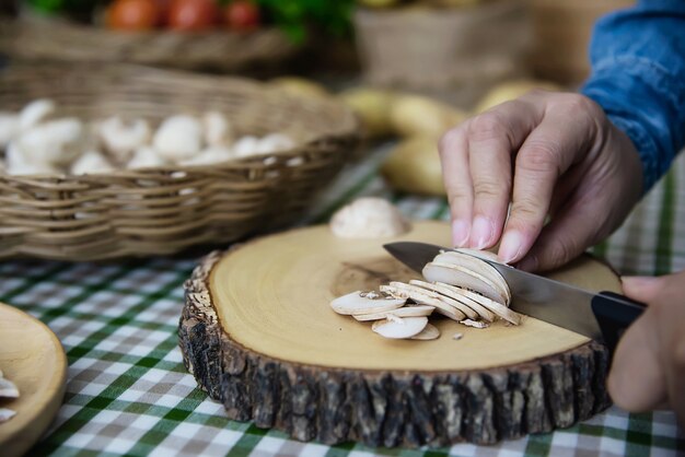 La señora cocina champiñones champiñones frescos en la cocina