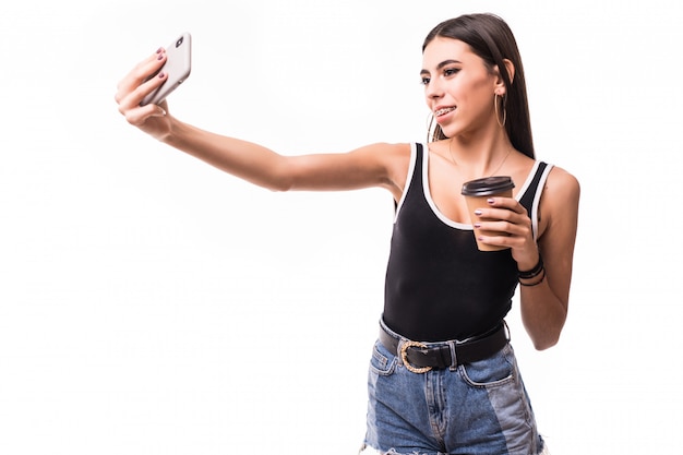 Señora divertida en resumen con taza de café hacer selfie en su teléfono aislado