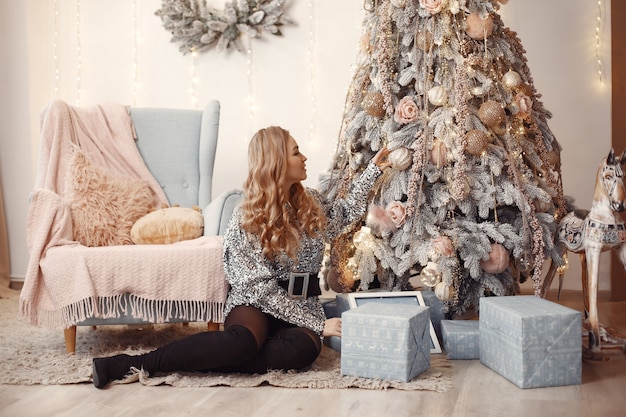 Señora elegante cerca del árbol de Navidad