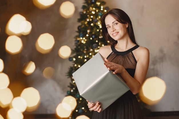 Señora elegante cerca del árbol de Navidad