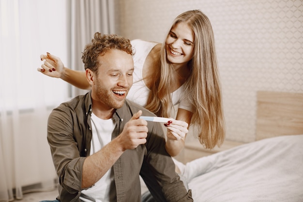 Señora emocionada diciéndole a su marido sobre su embarazo. Gente en casa. Feliz esposo.