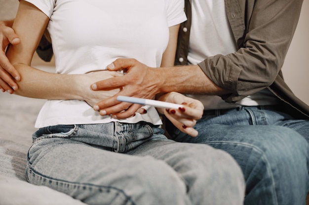 Señora emocionada diciéndole a su marido sobre su embarazo. Gente en casa. Feliz esposo.