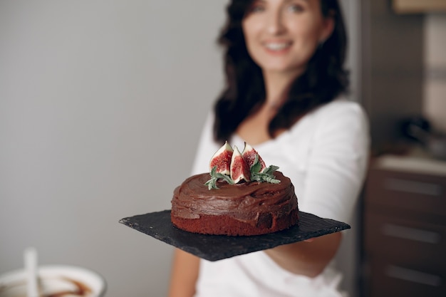 La señora está preparando el postre. La mujer hornea un pastel. Pastelero con tarta de chocolate.