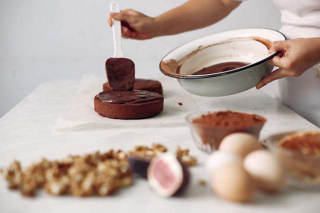 La señora está preparando el postre. La mujer hornea un pastel.