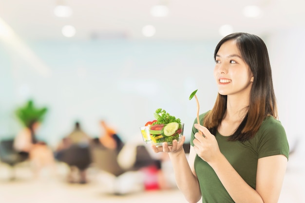 Señora feliz que sostiene cosas de la cocina sobre fondo del espacio de la copia