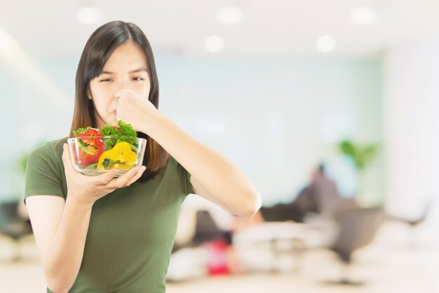 Señora feliz que sostiene cosas de la cocina sobre fondo del espacio de la copia