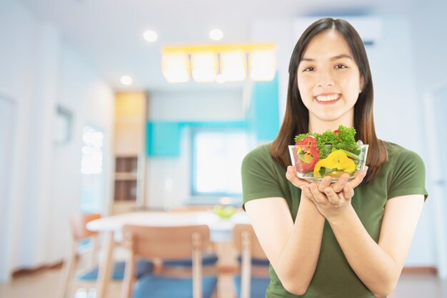 Señora feliz que sostiene cosas de la cocina sobre fondo del espacio de la copia