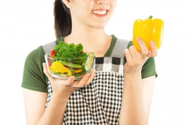 Señora feliz que sostiene cosas de la cocina sobre fondo del espacio de la copia