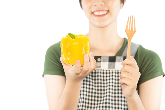 Señora feliz que sostiene cosas de la cocina sobre fondo del espacio de la copia