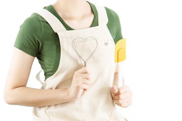 Señora feliz que sostiene cosas de la cocina sobre fondo del espacio de la copia