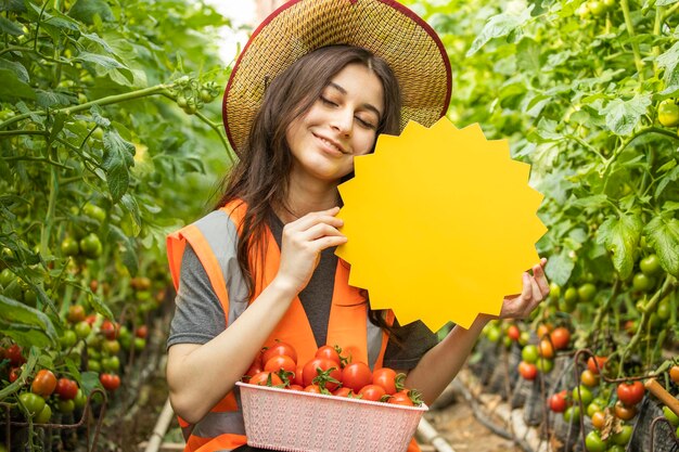 Señora hermosa sonriente que sostiene el tablero amarillo de la idea