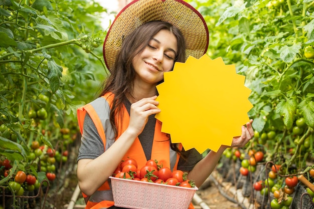 Señora hermosa sonriente que sostiene el tablero amarillo de la idea