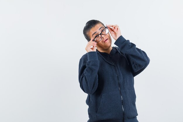 Señora joven con gafas en la vista frontal de la chaqueta.