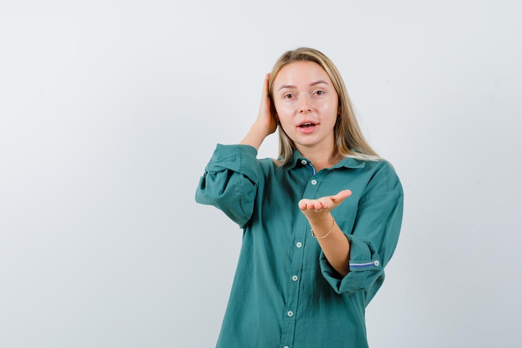 Foto gratuito señora joven que estira la mano en camisa verde y que parece atractiva.
