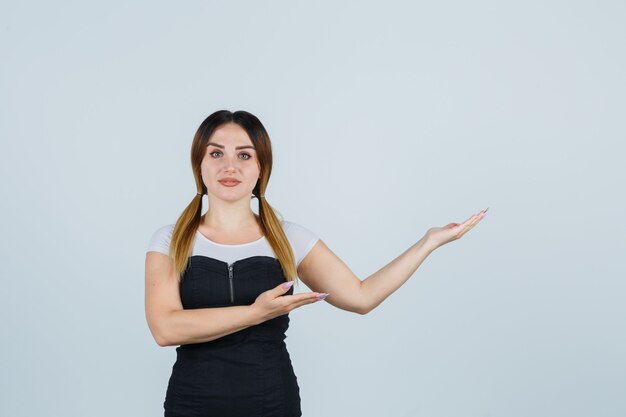 Señora joven rubia en vestido gesticulando aislado