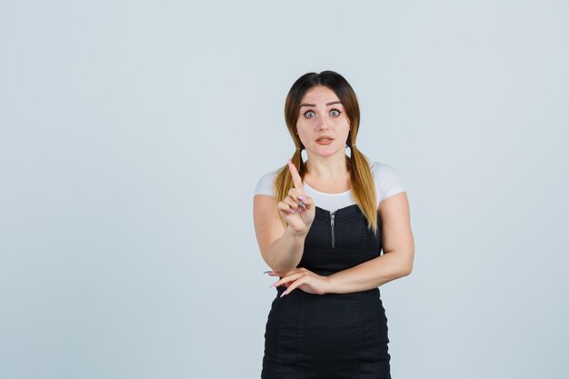 Señora joven rubia en vestido gesticulando aislado