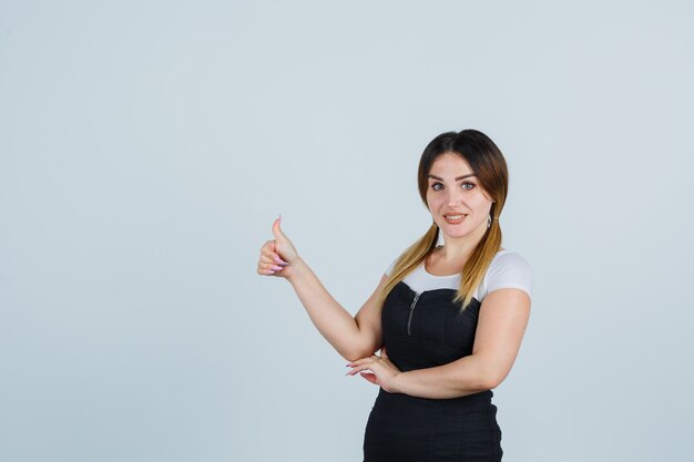 Señora joven rubia en vestido gesticulando aislado