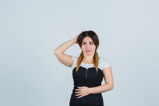 Señora joven rubia en vestido gesticulando aislado