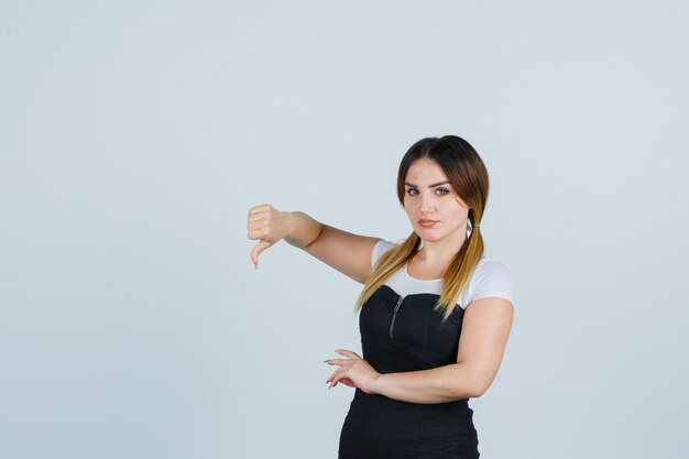 Señora joven rubia en vestido gesticulando aislado